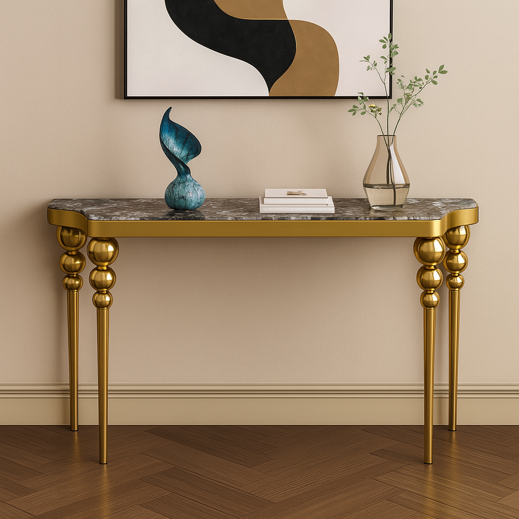 Console table with gold legs and marble top in a room with a painting on the wall.