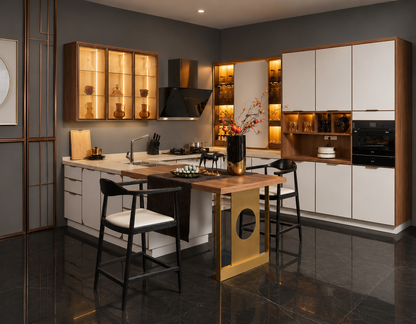 A modern kitchen interior with white and wood cabinetry, built-in black appliances, warm under-cabinet lighting, a central island with a wood top and gold-toned base, and two black bar stools with white seats on dark reflective tile flooring.