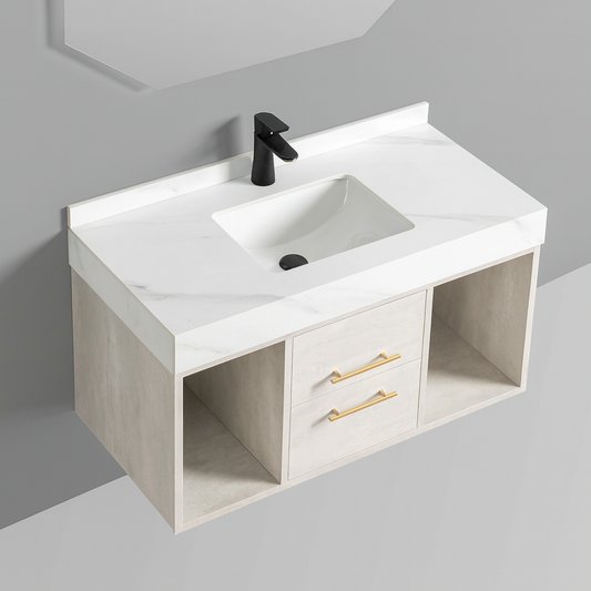Floating bathroom vanity with marble-inspired sintered stone countertop, integrated basin, matte light-cement cabinetry, gold drawer handles, and open shelving – SAIBA Homes.
