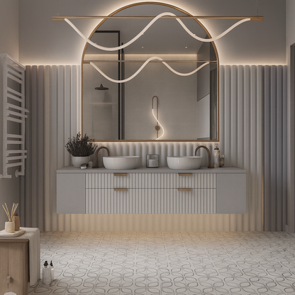 Floating double-basin vanity with fluted drawer fronts, gold hardware, curved faucets, large arched mirror, and ambient LED lighting – SAIBA Homes.