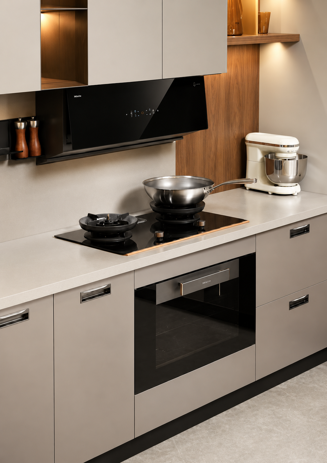 Modern kitchen cabinetry with a black glass cooktop, built-in oven, black range hood, and a white stand mixer on a light countertop.