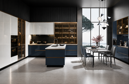 A modern kitchen and dining room interior with dark blue and white cabinetry, open wood shelving with warm lighting, a central kitchen island, and a dining table with chairs near large windows.