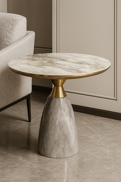 Round marble table with a gold base next to a sofa in a room.