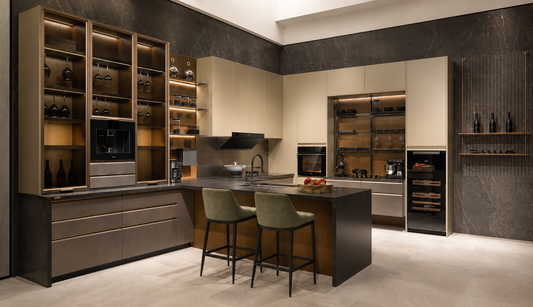 A luxury modern kitchen interior featuring cream-colored cabinets, dark wood cabinetry, glass-front shelves with warm lighting, a central island, and two green bar stools.