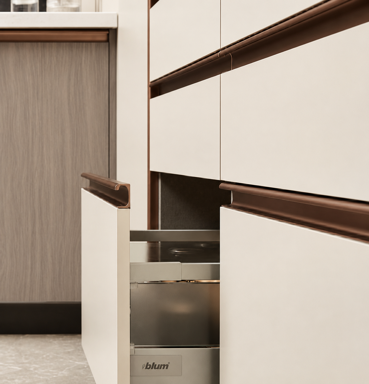 A close-up of modern kitchen cabinetry with white drawer fronts and dark brown handles, with one drawer pulled open to reveal a stainless steel interior. The brand name 'ibham' is visible on the bottom edge of the open drawer.