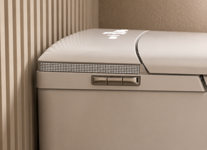 Close-up of a cream-colored appliance, likely a refrigerator or freezer, showing the top lid, a horizontal ventilation grille, and a control handle, set against a background of beige ribbed wall panels and a textured beige wall.