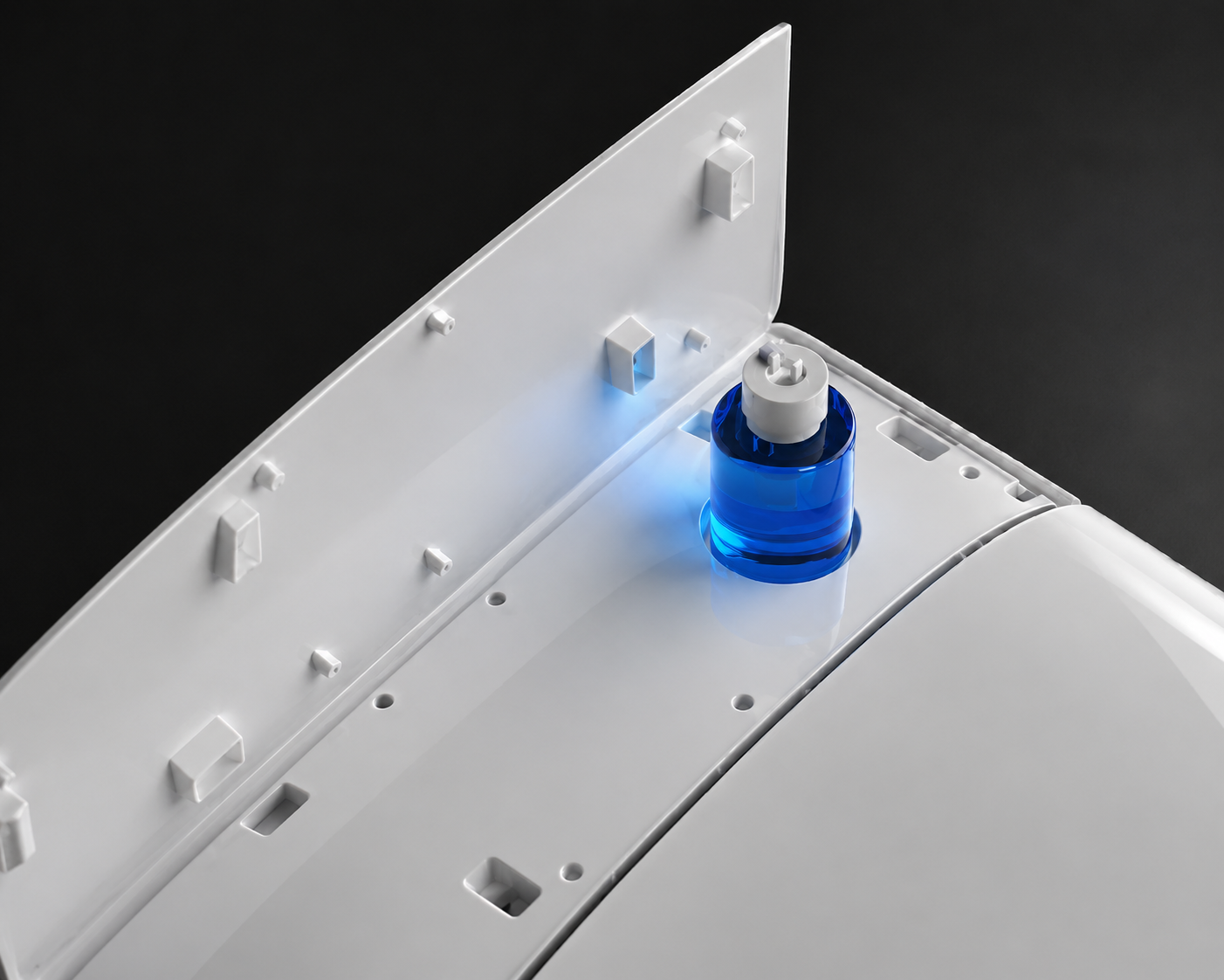 Close-up of a white appliance interior or panel with a small translucent blue cylindrical component and a white screw fastener, shown against a dark background.
