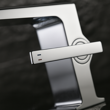 High-contrast polished chrome handle with hot and cold markers on a bathroom faucet with temperature display