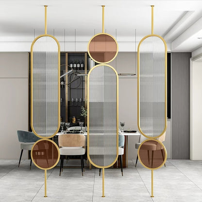 Wall Partition in gold with curved ribbed glass panels and circular tinted accents in a modern dining room.