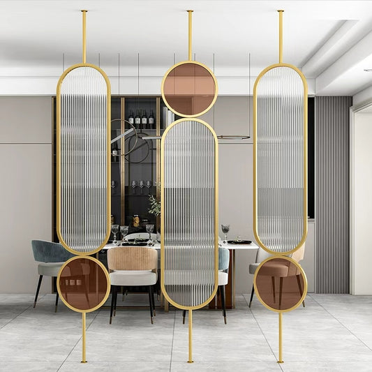 Wall Partition in gold with curved ribbed glass panels and circular tinted accents in a modern dining room.