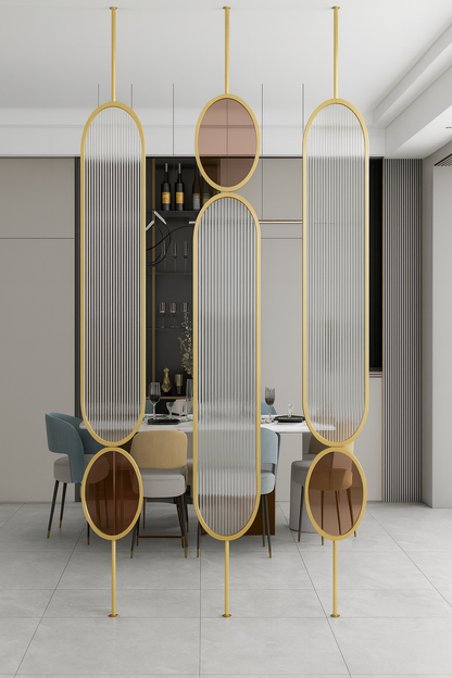 Contemporary glass partition with gold frame and sculptural panel design used as a feature divider in a modern living space.
