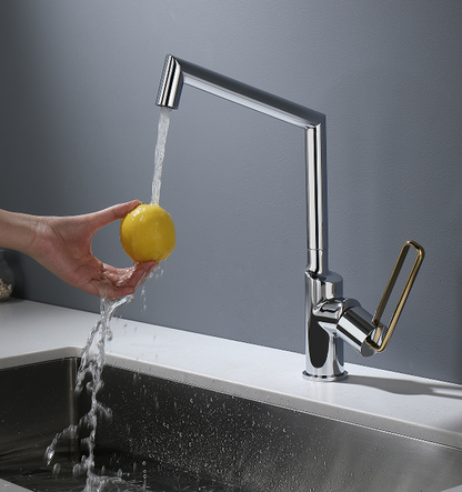 Hand washing a lemon under a modern kitchen faucet with a gray background